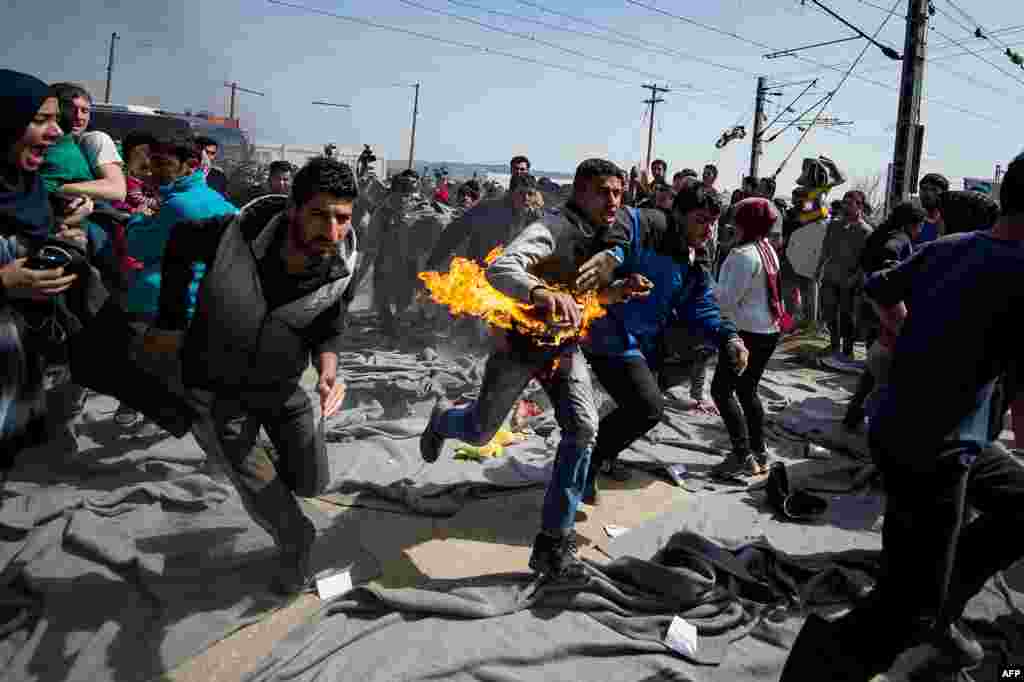 A man runs after trying to set himself on fire during a protest at a makeshift migrant camp in Idomeni near the Greek-Macedonian border on March 22. (AFP/Andrej Isakovic)