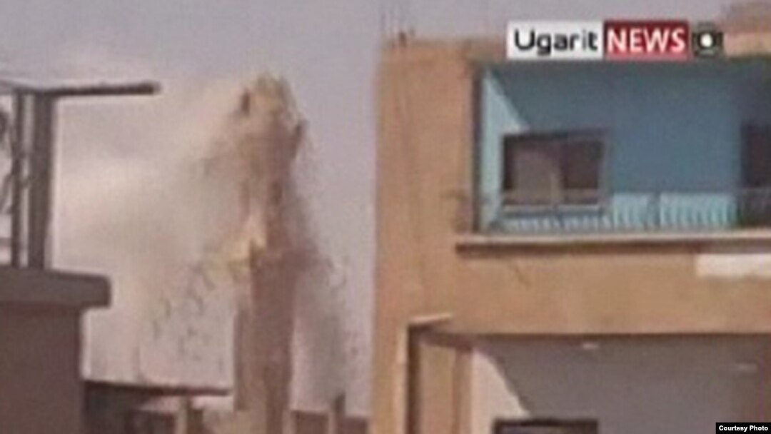 Минарет, разрушающийся во время перестрелки в одном из сирийских городов. 11 августа 2011 г