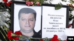 Russia -- A portrait of Russian Lieutenant Colonel Oleg Peshkov among flowers outside the Russian Defence Ministry building in Moscow, November 26, 2015