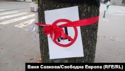 Плакат със задраскана буква "Д", поставен на дърво пред Съдебната палата в София след протеста на граждани срещу Делян Пеевски от 25 септември. Подобни плакати станаха популярни на протестни прояви след изказването на Делян Пеевски, че ще прави "държава с главно Д".