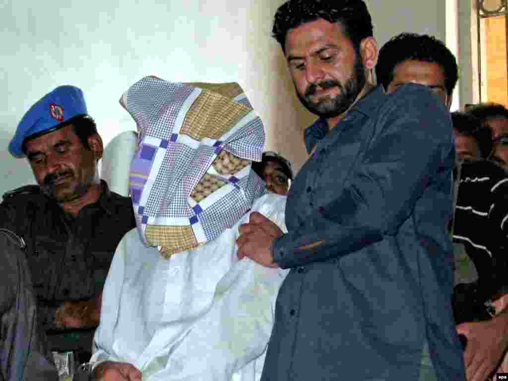 Pakistan -- Police escort blind-folded alleged Taliban militants, to a court after they were arrested in Karachi, 20Oct2009 - Caption: epa01903777 Pakistani Police escort blind-folded alleged Taliban militants, to a court after they were arrested in southern port city of Karachi, Pakistan, 20 October 2009. Police in Karachi on October 19, arrested four alleged members of banned militant outfit Tehrik-e-Taliban Pakistan (Movement of Pakistani Taliban). Pakistani security forces has already begun ground offensive against Taliban and al-Qaeda insurgents in the Pakistan's lawless South Waziristan tribal region along the Afghan border.
