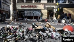 Cenușă și deșeuri pe marginea unei străzi din Paris pe 18 octombrie, a doua zi după ciocnirile violente din timpul protestelor de sâmbătă împotriva creșterii prețurilor 
