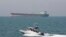 FILE-- In this July 2, 2012 file photo, an Iranian Revolutionary Guard speedboat moves in the Persian Gulf while an oil tanker is seen in background. 