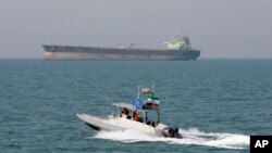 FILE-- In this July 2, 2012 file photo, an Iranian Revolutionary Guard speedboat moves in the Persian Gulf while an oil tanker is seen in background. 