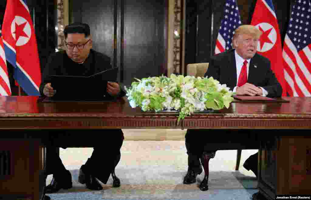 Дональд Трамп комментирует подписание документа в то время, как Ким Чен Ын рассматривает только что подписанный документ.&nbsp;&quot;Сегодня у нас прошла историческая встреча, мы решили оставить прошлое позади. Мы решили подписать исторический документ &ndash; заявил северокорейский лидер Ким Чен Ын. &ndash; Мир увидит большое изменение&quot;.&nbsp;