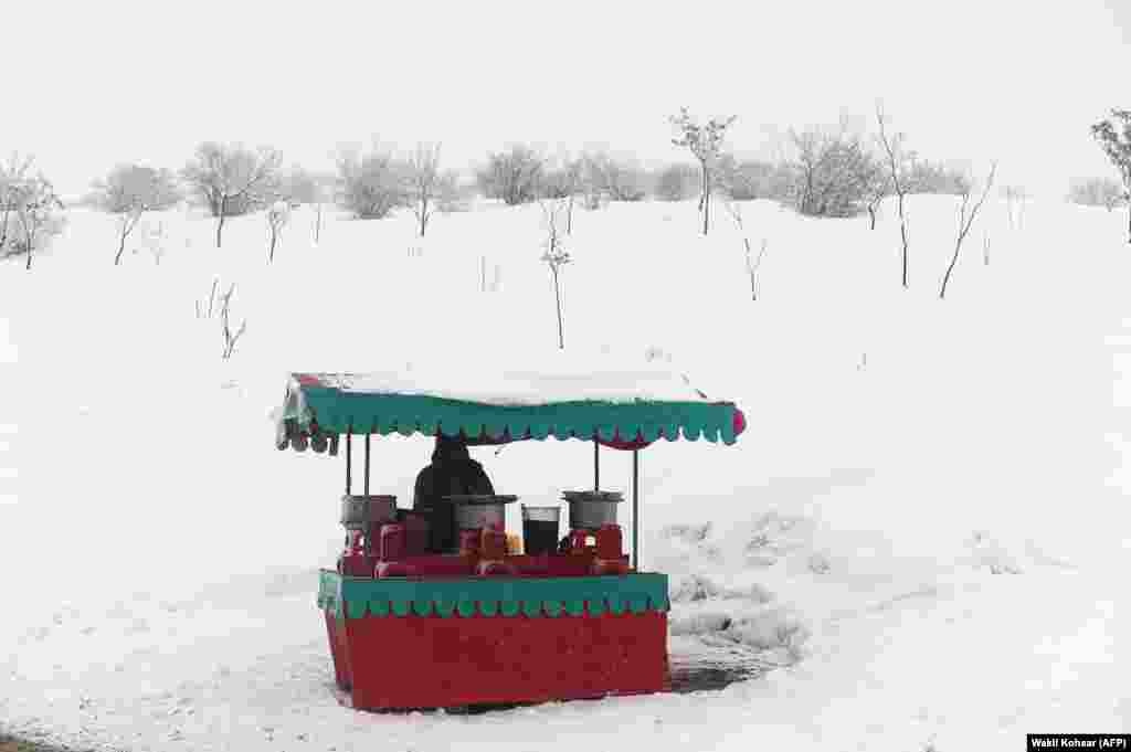 An Afghan chickpea vendor looks on as he waits for customers at his roadside stall near Qargha Lake on the outskirts of Kabul. (AFP/Wakil Kohsar)