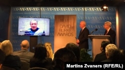 BBG CEO John Lansing (center) and RFE/RL President Thomas Kent (right), listen to recorded comments by RFE/RL Crimea journalist Mykola Semena at the 2016 David Burke Awards ceremony in Washington.