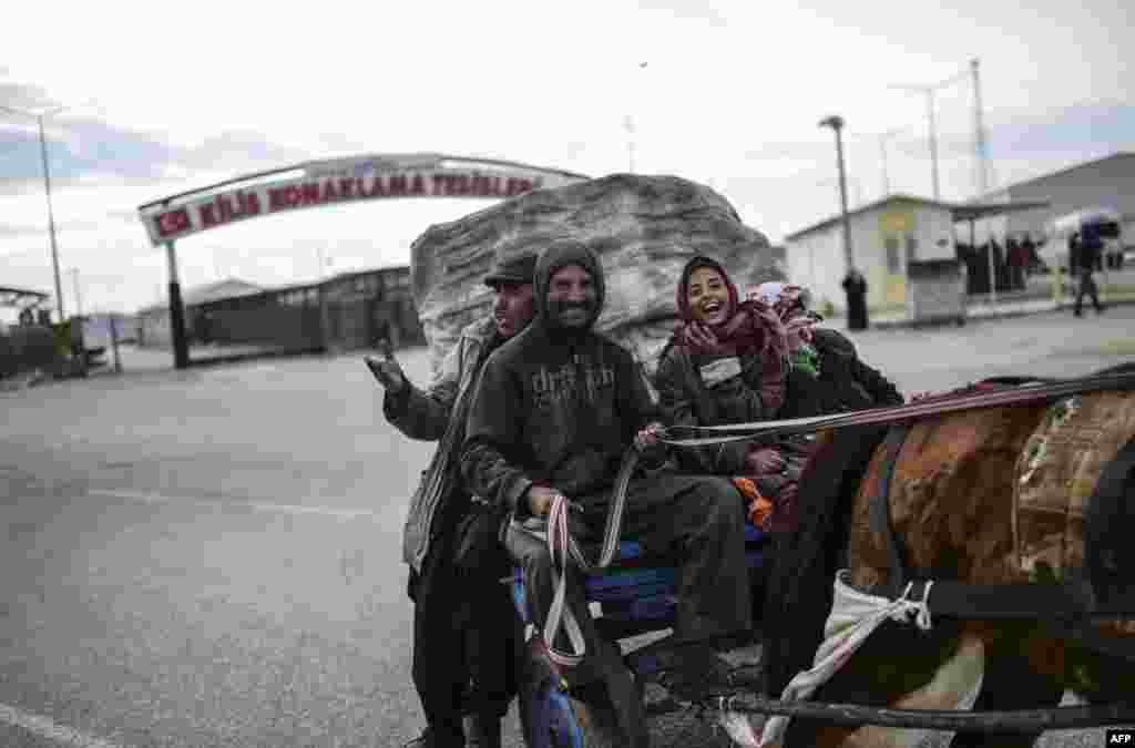 A Turkish family, who earn their living by collecting garbage, ride their cart near the town of Kilis, central Turkey. (AFP/Bulent Kilic)