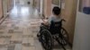 A patient suffering from the coronavirus disease (COVID-19) sits in a wheelchair at University Hospital Medical Center Bezanijska kosa in Belgrade