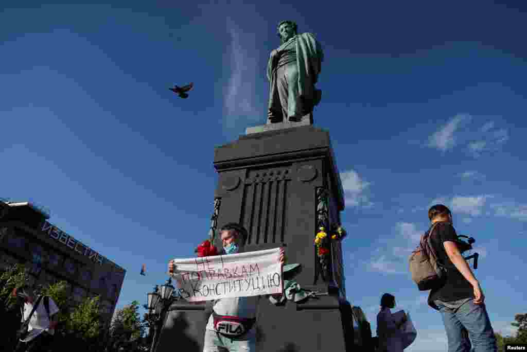 Мужчина держит плакат с надписью &laquo;Нет поправкам в Конституцию&raquo; под памятником Пушкина в Москве