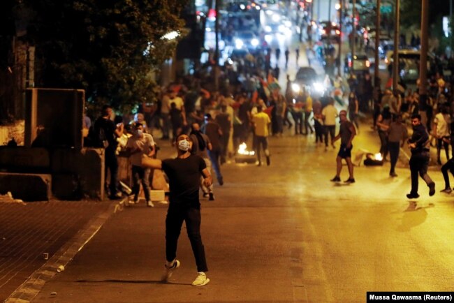 Një protestues palestinez hedh gurë në drejtim të policisë izraelite. Bregu Perëndimor, 10 maj, 2021.