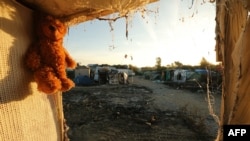 France -- A teddy bear left behind my migrants hangs at the demolished "Jungle" migrant camp in Calais in northern France on October 28, 2016.