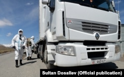 Chinese border officials sanitize trucks at a border crossing with Kyrgyzstan as part of Beijing’s strict COVID-19 measures.