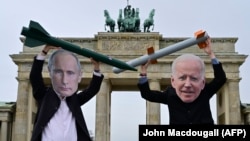 Активісти в масках президента Сполучених Штатів Джо Байдена та президента Росії Володимира Путіна із муляжами ядерних ракет в Берліні, січень 2021 року