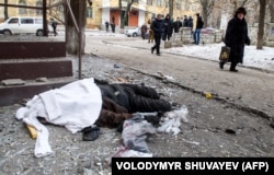  Хора минават около тялото на жертва след обстрел в източния украински град Крамоторск, 10 февруари 2015 година 
