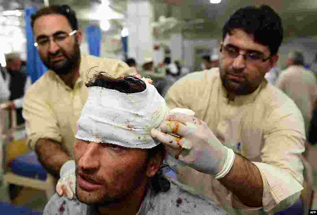 Pakistani paramedics treat an injured man in Peshawar, Pakistan.