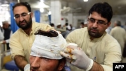 Pakistani paramedics treat a man injured in an earthquake at a hospital in Peshawar on October 26.