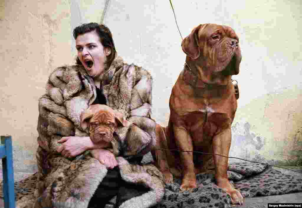 A woman yawns as she tries to sell a puppy at a street market in St. Petersburg, 1999.