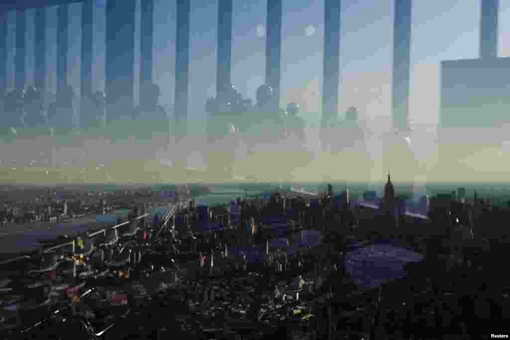 Members of the media are reflected in the windows of the 100th floor observation deck in the One World Trade Center in New York. Port Authority officials unveiled the stunning views on April 2, which will instantly become one of the city&rsquo;s premiere tourist attractions when the building is completed in 2015. (Retuers/Lucas Jackson)