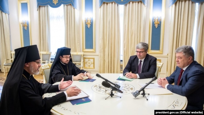 Зліва направо: екзархи Вселенського патріархату в Україні, архієпископ Памфільський і Західної єпархії УПЦ в США Даниїл і єпископ Едмонтона і Захiдної єпархії УПЦ в Канаді Іларіон, директор Національного інституту стратегічних досліджень при президенті України Ростислав Павленко та президент України Петро Порошенко. Київ, 16 жовтня 2018 року
