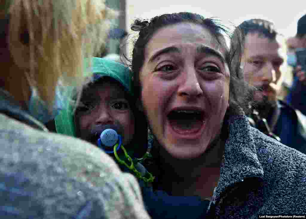 A woman holding a child reacts during an opposition rally to demand the resignation of Armenian Prime Minister Nikol Pashinian following the signing of a deal to end the military conflict over the Nagorno-Karabakh region, in Yerevan on November 11. (Lusi Sargsyan/Photolure via Reuters)