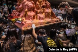 Studenții din Hong Kong curăță „Stâlpul Rușinii”, monument al artistului danez Jens Galschiot consacrat victimelor represiunii sângeroase din Piața Tiananmen, de la Beijing, din 1989 - 4 iunie 2020