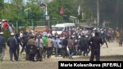 Protesters gather as smoke rises near the main point of confrontation with police on the main road to Kumtor gold mine on May 31, when clashes injured dozens of people.