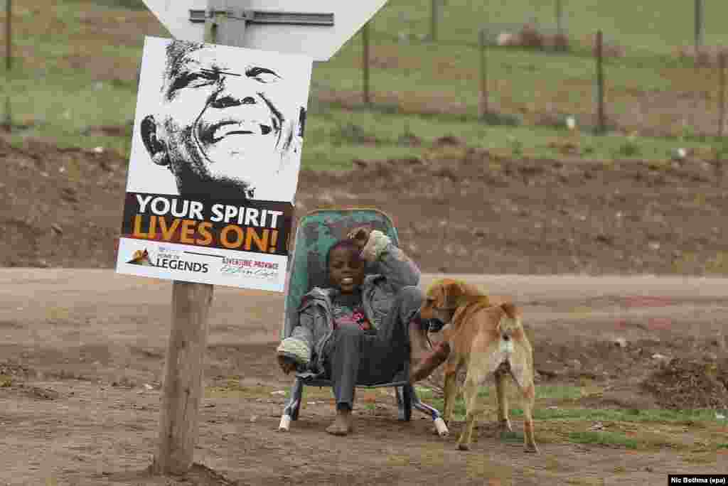 A boy rests in a wheelbarrow near the home of the late South African President Nelson Mandela in his ancestral village of Qunu. (epa/Nic Bothma)