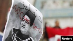 Demonstrant drži Mubarakovu fotografiju sa na jednom od protesta protiv njegove vladavine
