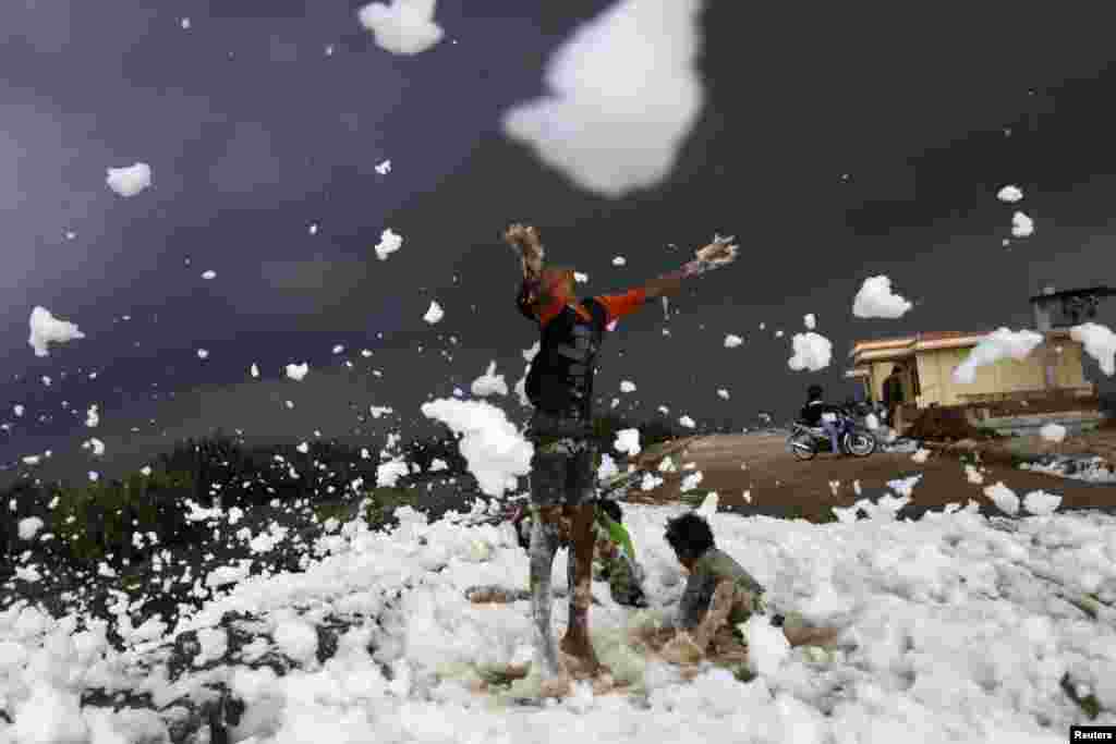 Children play on foam from a polluted river at the Marunda flood canal in Jakarta, Indonesia.