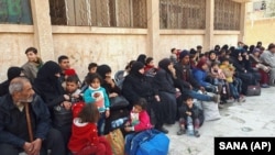 Syrian civilians, who fled fighting in eastern Ghouta, at an army checkpoint in Damascus on March 13.