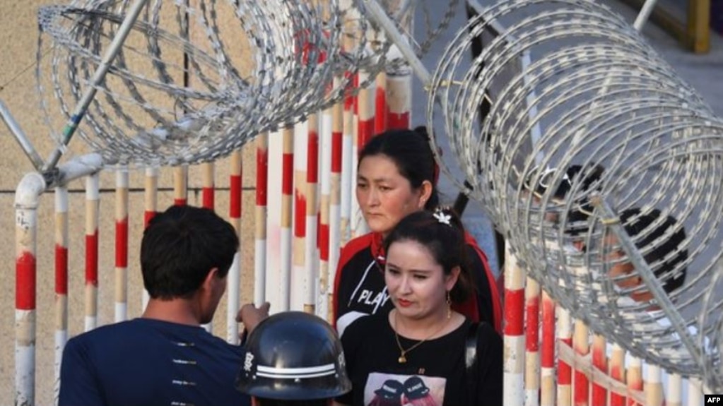 Uyghur women walk through a security checkpoint to enter a bazaar in Hotan, in China's Xinjiang Uyghur Autonomous Region.