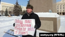Бекболат Утебаев на центральной площади Уральска держит плакат «Свободу политзаключенным».
