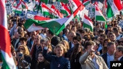 Hungarian opposition leader and president of the Tisza (Respect and Freedom) party Peter Magyar (center) waves a Hungarian flag during a campaign rally organized by Hungary's Tisza party in Budapest on March 15.