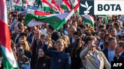 Lideri i opozitës hungareze dhe presidenti i partisë Tisza, Peter Magyar (në qendër), valëvit flamurin hungarez gjatë një tubimi elektoral të organizuar nga partia hungareze Tisza, në Budapest, më 15 mars.