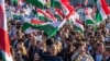 Hungarian opposition leader and president of the Tisza (Respect and Freedom) party Peter Magyar (center) waves a Hungarian flag during a campaign rally organized by Hungary's Tisza party in Budapest on March 15.