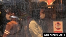 IRAN -- Iranian women wearing face masks ride a bus amid the novel coronavirus pandemic in the capital Tehran, August 9, 2020