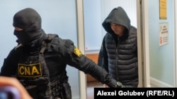 Ofițerul superior INI, Andrei Ciobanu (dreapta), escortat la Judecătoria Ciocana, unde se examinează cererea de arest