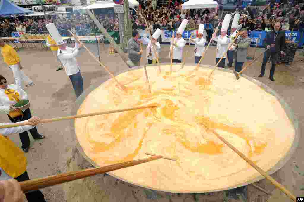 Members of the Giant Omelet Brotherhood of Bessieres cook a giant omelet as part of Easter celebrations on the main square of Bessieres, southern France. Over 15,000 eggs were used to make the omelet. (AFP/Remy Gabalda)