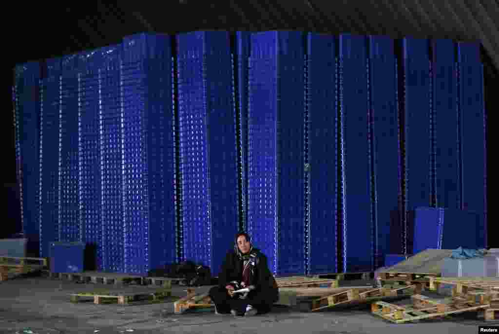 An Afghan election official sits near ballot boxes in a warehouse in Kabul on the eve of the June 14 voting. (Reuters/Mohammad Ismail)