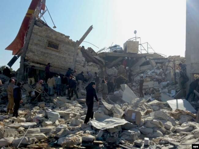 People gather near a destroyed building said to be a Medecins Sans Frontieres (MSF) supported hospital in Marat al Numan, Idlib, Syria, in February 16.