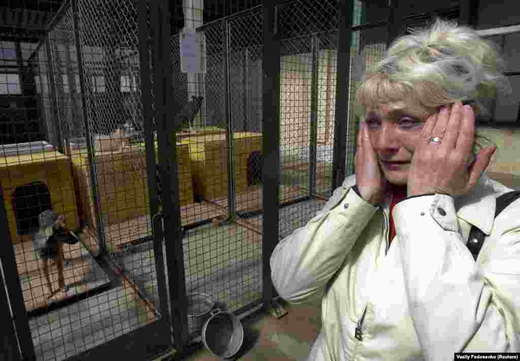 A woman weeps after leaving her sick dog, which she could no longer afford to take care of, at a shelter in Minsk.