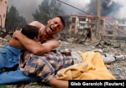 Грузин плаче над тілом близької людини після бомбардування Ґорі, 9 серпня 2008 року