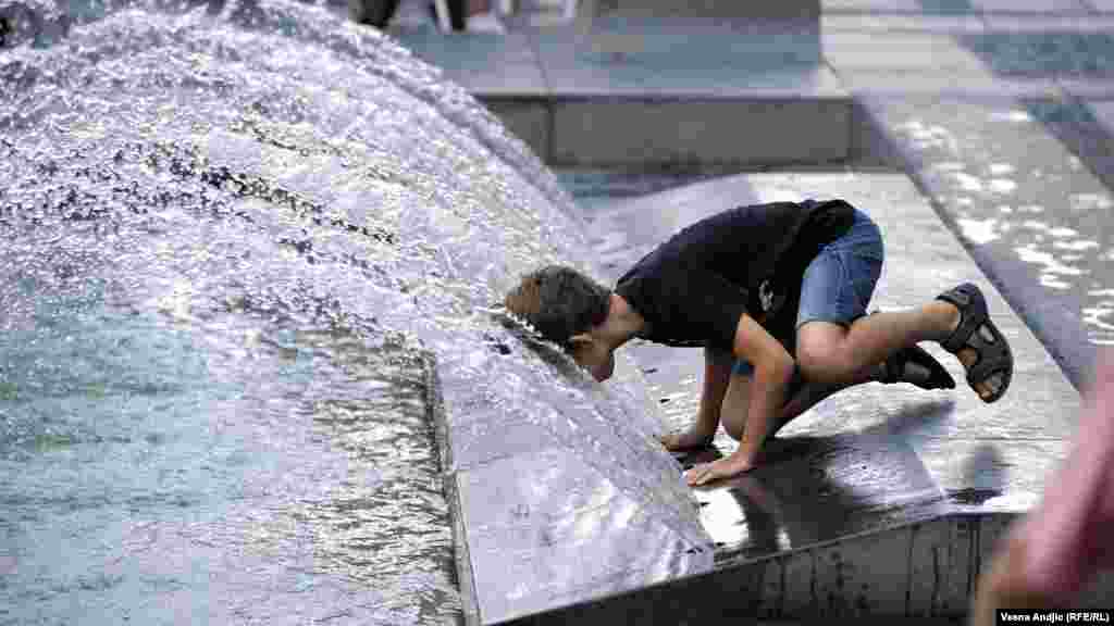 A young boy cools off in a Belgrade fountain on July 29.&nbsp;