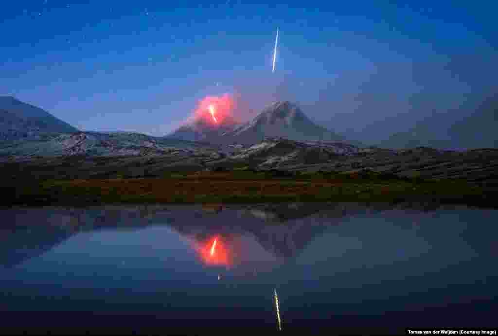 Этот снимок метеорита, падающего на извергающийся вулкан Ключевская Сопка, сделан на Камчатке голландским фотографом Томасом ван дер Вейденом. &quot;Мы решили подождать еще час, понаблюдать за извержением, &ndash; рассказывает Томас. &ndash; В это время облака расступились, и нам открылся прекрасный вид на стекающую в темноте по склону лаву. Потом произошла бело-зеленая вспышка, люди закричали от неожиданности. Я успел нажать на спуск своего фотоаппарата и подумал при этом: &quot;Надеюсь, я успел это снять&quot;. Оказалось, что действительно успел. Это была большая радость&quot;. &nbsp;