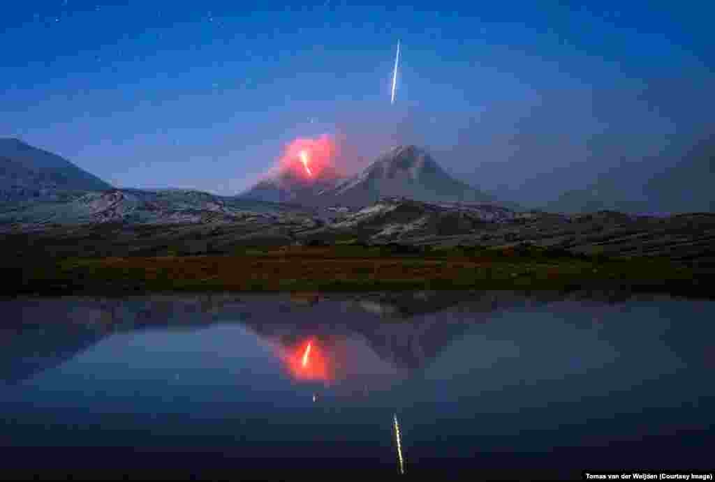 Fotograf Tomas van der Weijden bio je na foto turneji koja se poklopila sa erupcijom Klyuchevskaya Sopka, vulkana koji je bio uspavan dvije godine. Kad je grupa čula vijest o erupciji, krenuli su do vidikovca, ali pogled je bio umotan u oblak i ništa se nije moglo vidjeti. &nbsp; &ldquo;Odlučili smo čekati još jedan sat, a onda se oblak iznenada podigao i mogli smo vidjeti lavu u tami&rdquo;, kaže Van der Weijden. Holandski fotograf kliknuo je okidač za fotografisanje na 15 sekundi, i &quot;pojavio se taj veliki zeleni i bijeli bljesak ... ljudi su vrisnuli. Pomislio sam: &nbsp;Nadam se da sam to snimio. I jesam. Bio je to divan momenat.&rdquo; &nbsp; &nbsp; &nbsp;