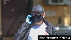 Мужчина в защитной маске идет по улице. Алматы.
