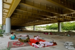 Hindu refugees from Pakistan rest under Signature bridge, a highway overpass, to avoid the summer heat near a Hindu refugee settlement situated in a woodland area in New Delhi.