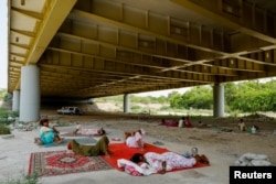 Hindu refugees from Pakistan rest under Signature bridge, a highway overpass, to avoid the summer heat near a Hindu refugee settlement situated in a woodland area in New Delhi.