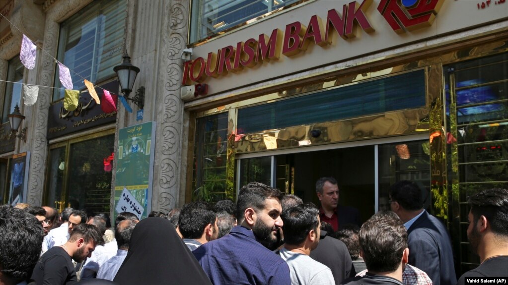 IRAN -- Iranians stand in front of a bank, hoping to buy U.S. dollars at the new official exchange rate announced by the government, in downtown Tehran, April 10, 2018